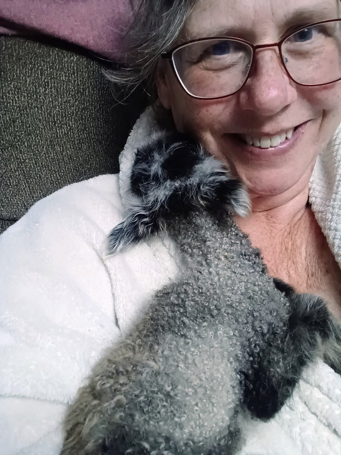 A very large photo of Shannon cuddling a newborn lamb